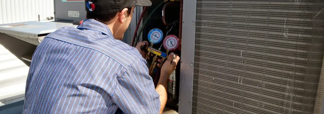 HVAC technician servicing a condenser unit in Boiling Spring Lakes